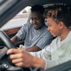father practice-driving with son
